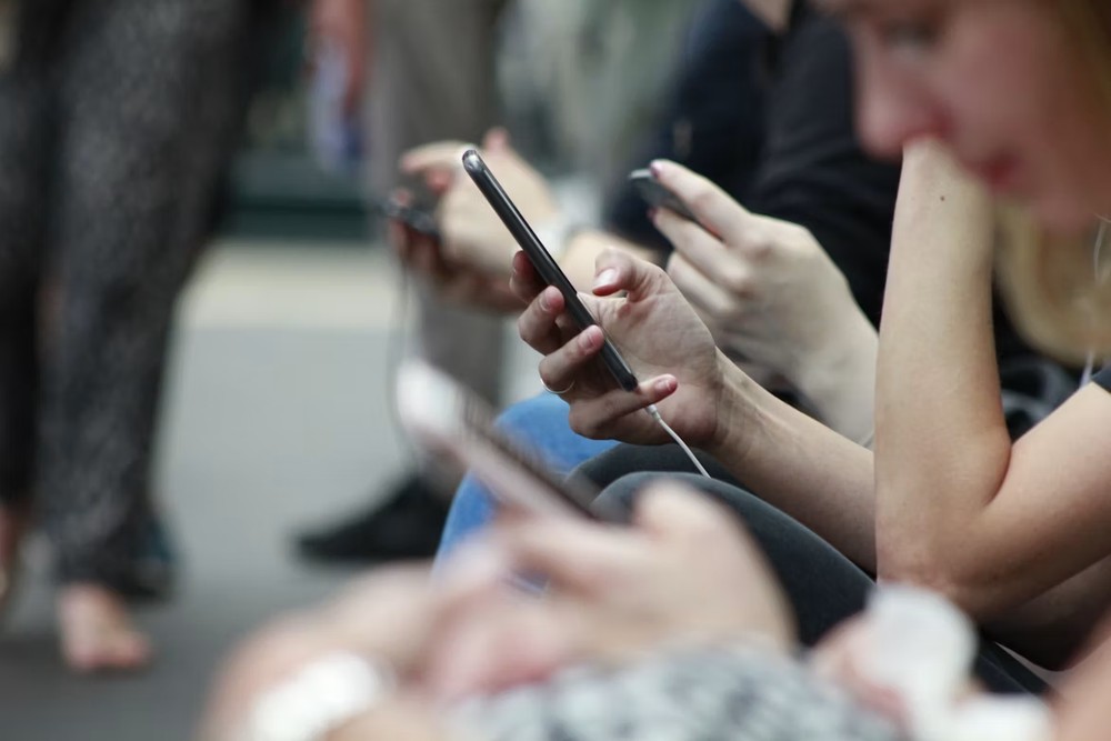 Pessoas segurando celular — Foto: Reprodução/Unsplash