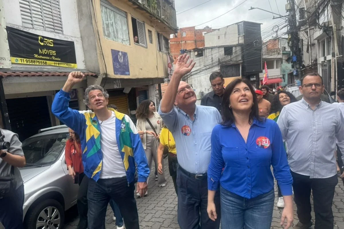 Imagem colorida mostra caminhada com Alckmin, Haddad e Tebet em Heliópolis. Metrópoles